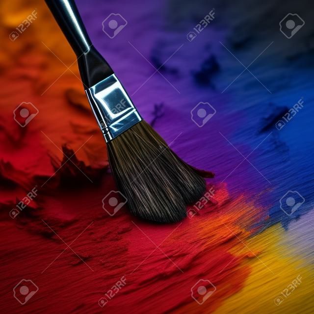 Pincel y paleta de colores en un primer plano de fondo oscuro