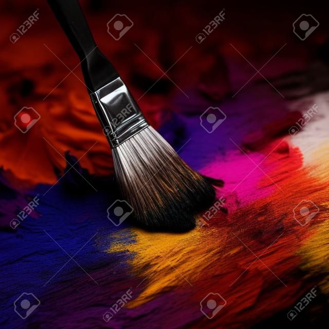 Pinceau et palette de couleurs sur un fond sombre gros plan