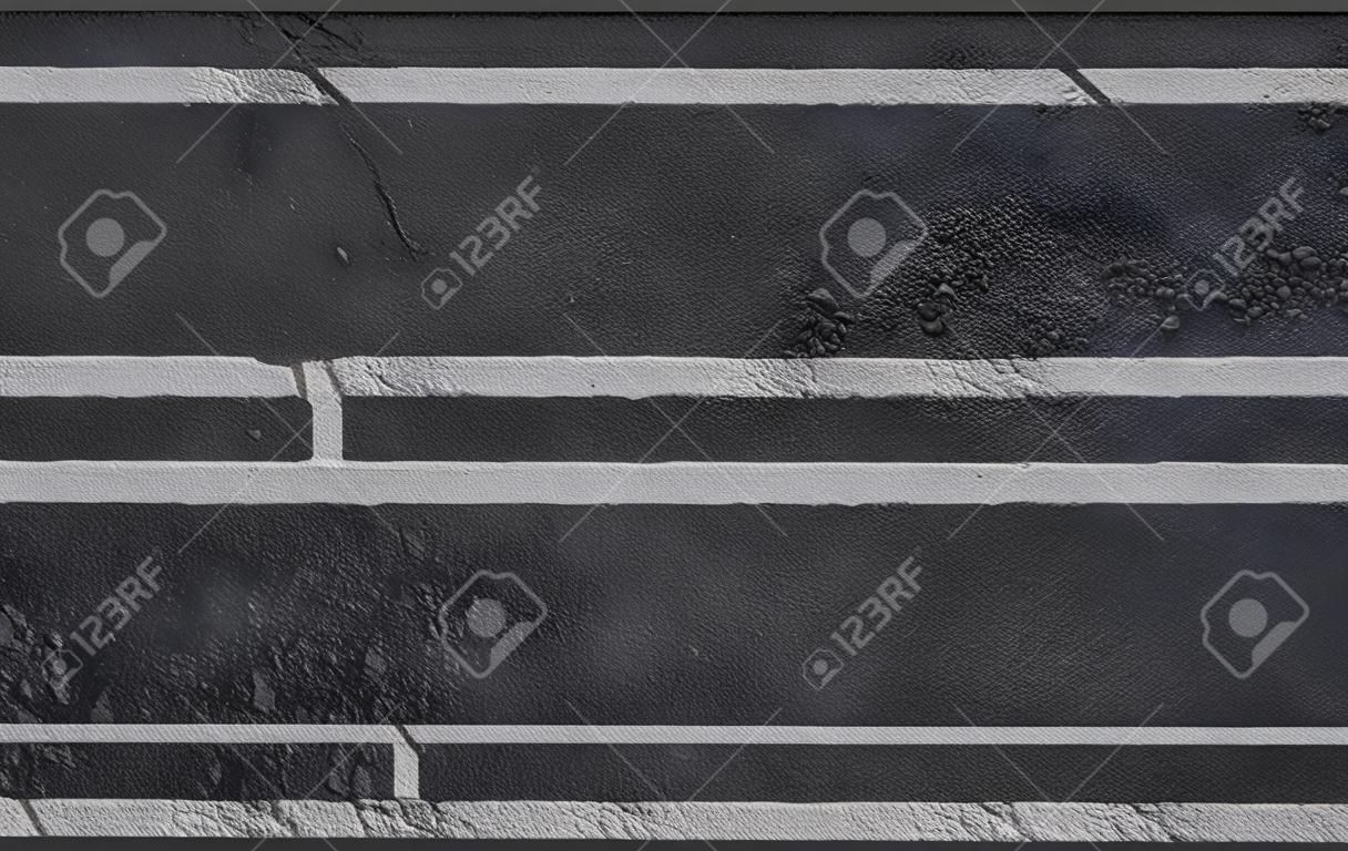 在沥青路面纹理背景的白色stripess