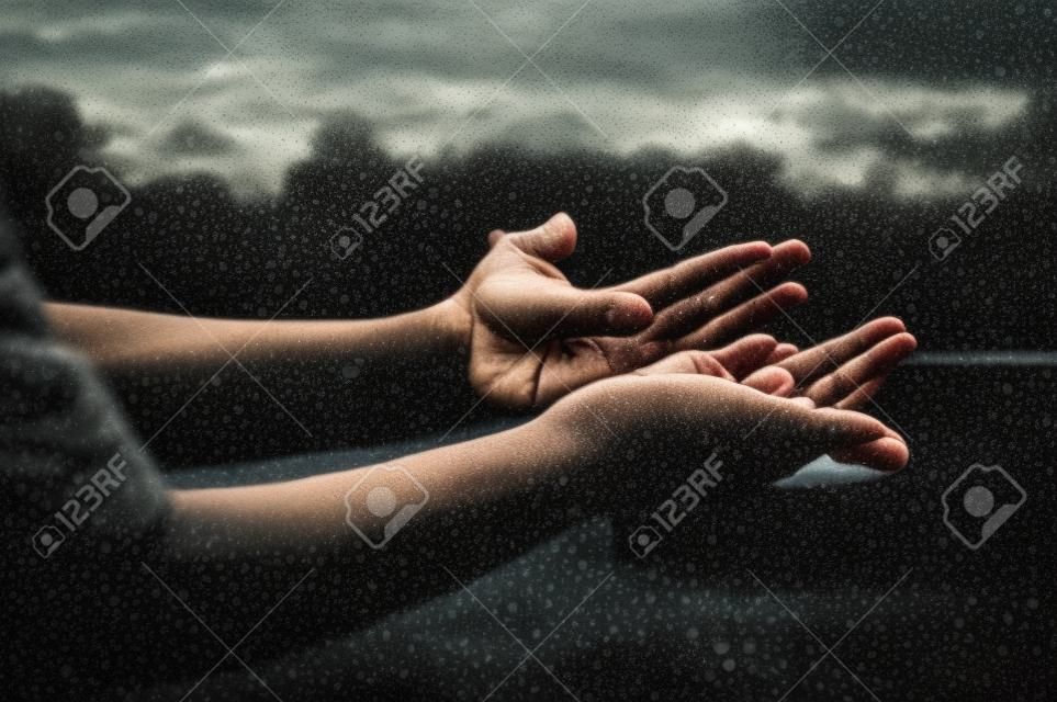 Mãos de mulher orando por bênção de Deus, fundo de natureza turva, chuva, dia. Mãos vazias abertas humanas religiosas com as palmas das mãos para cima. Gratidão, adoração ao pregador, oração de solidão, conceito de devoção religiosa