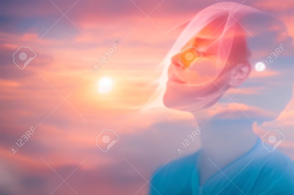 Doppeltes Mehrfachbelichtungsporträt einer verträumten süßen Frau, die mit geschlossenen Augen im Freien meditiert, kombiniert mit Naturfoto, Sonnenaufgang oder Sonnenuntergang, Nahaufnahme. Psychologie Freiheit Macht des Geistes Konzept