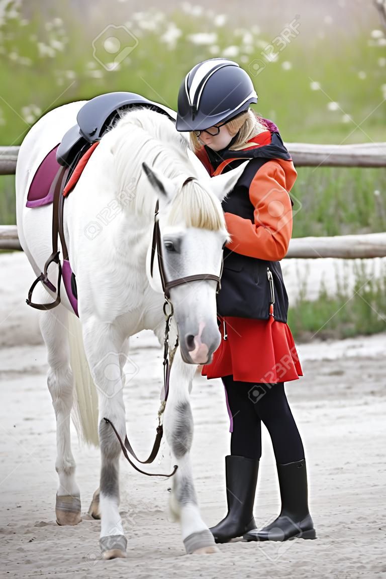 young girl with white little horse outdoors