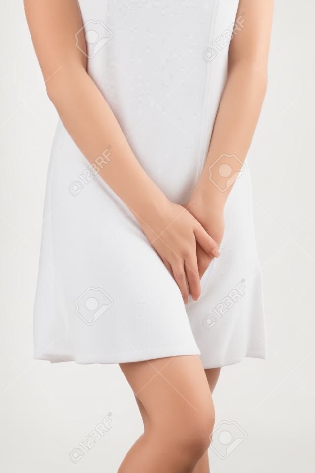 Perto de uma mulher com as mãos segurando sua virilha, isolada no branco
