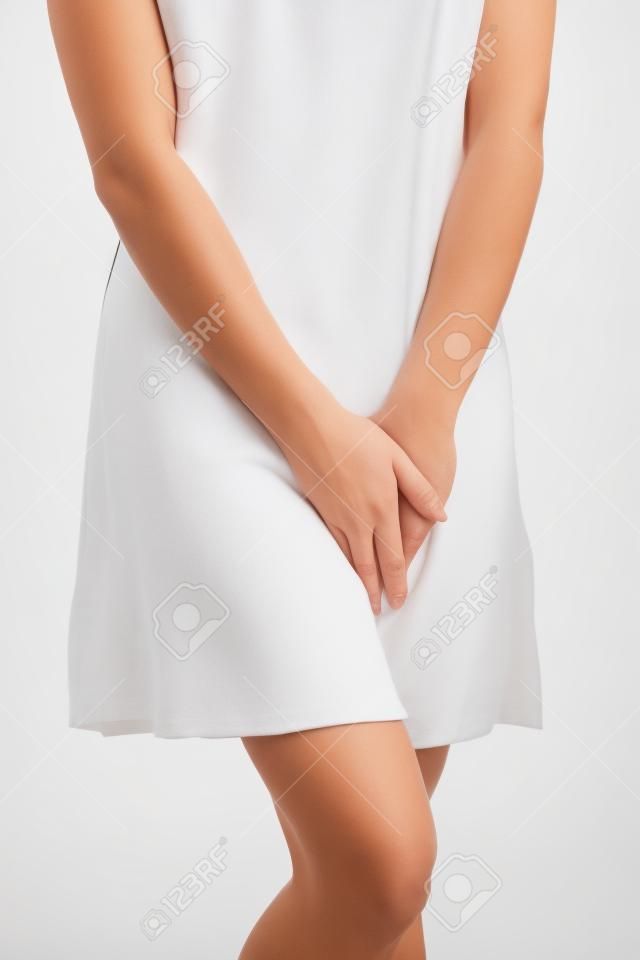 Gros plan d'une femme avec les mains tenant son entrejambe, isolé en blanc