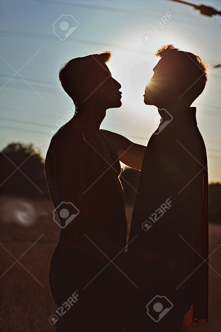 Silhueta de dois homens prestes a beijar