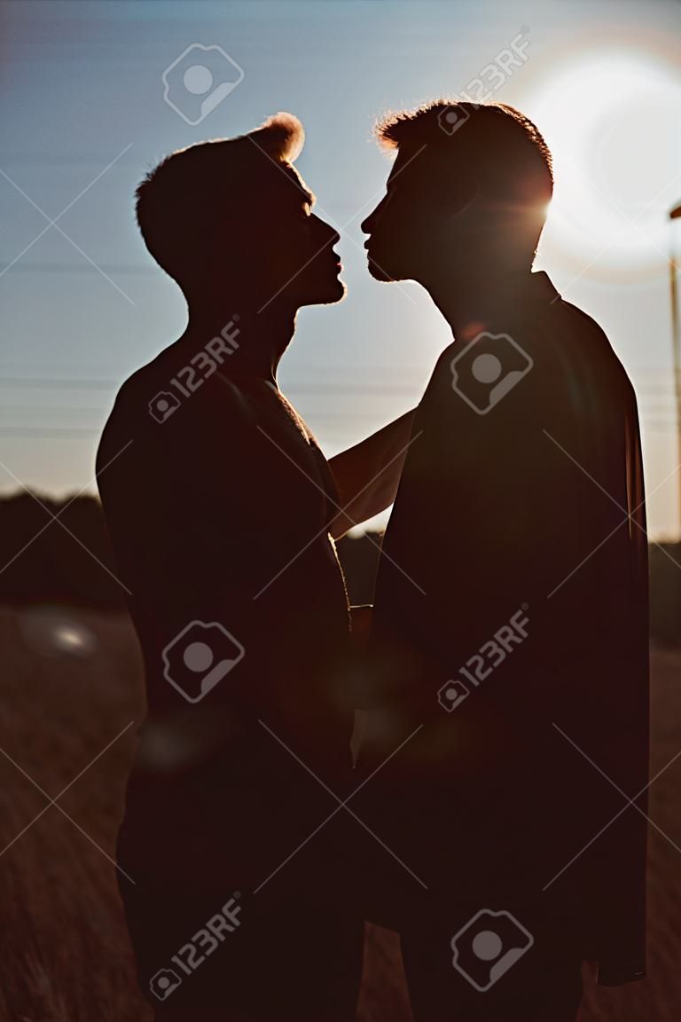Silhueta de dois homens prestes a beijar