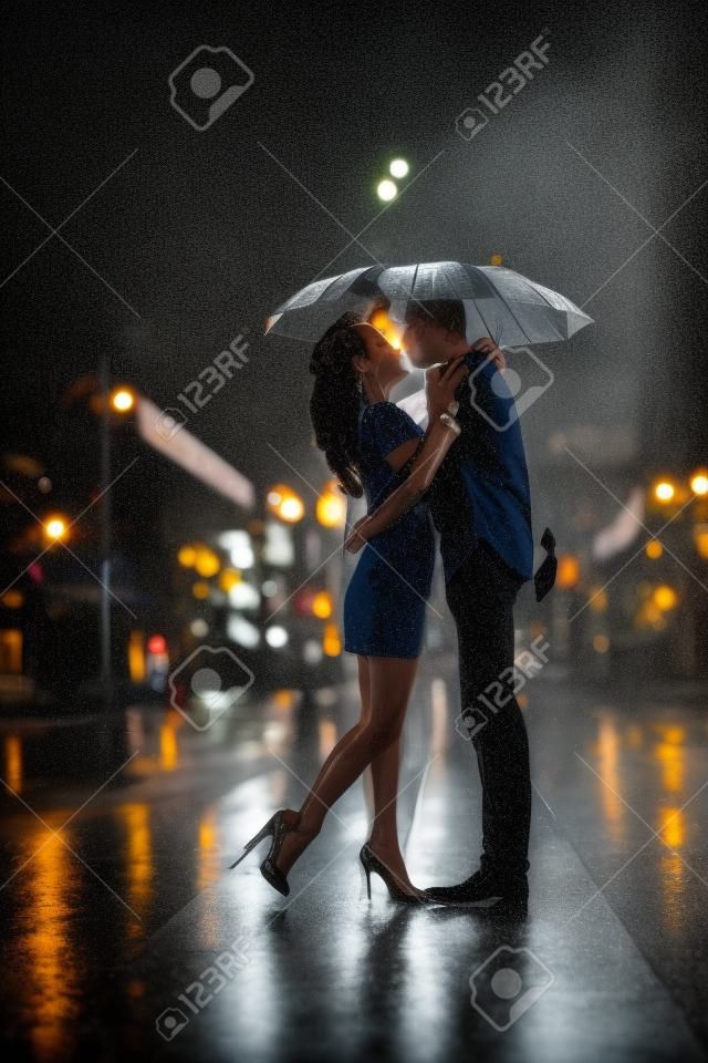 happy couple kissing under  the rain