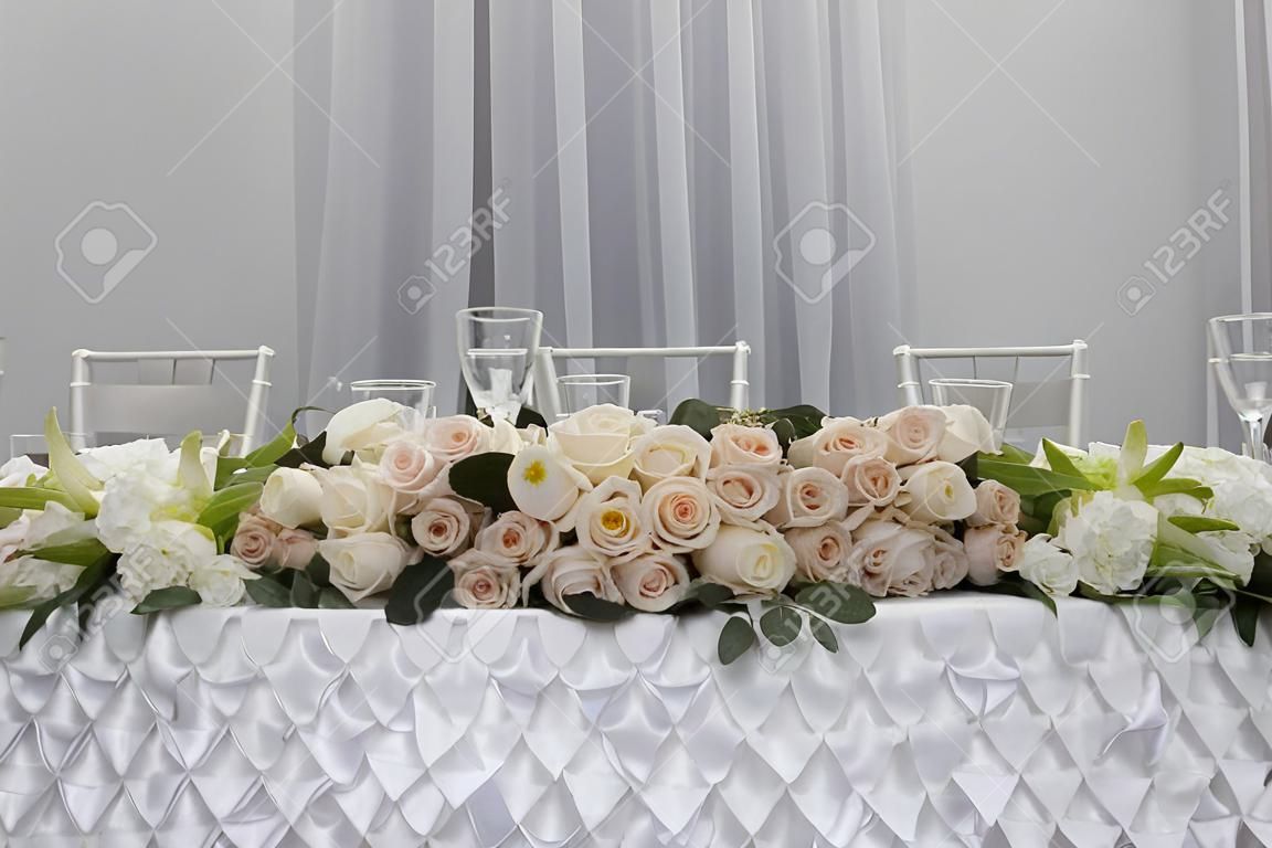 Сервировка стола на роскошь свадебного приема. Красивые цветы на столе.