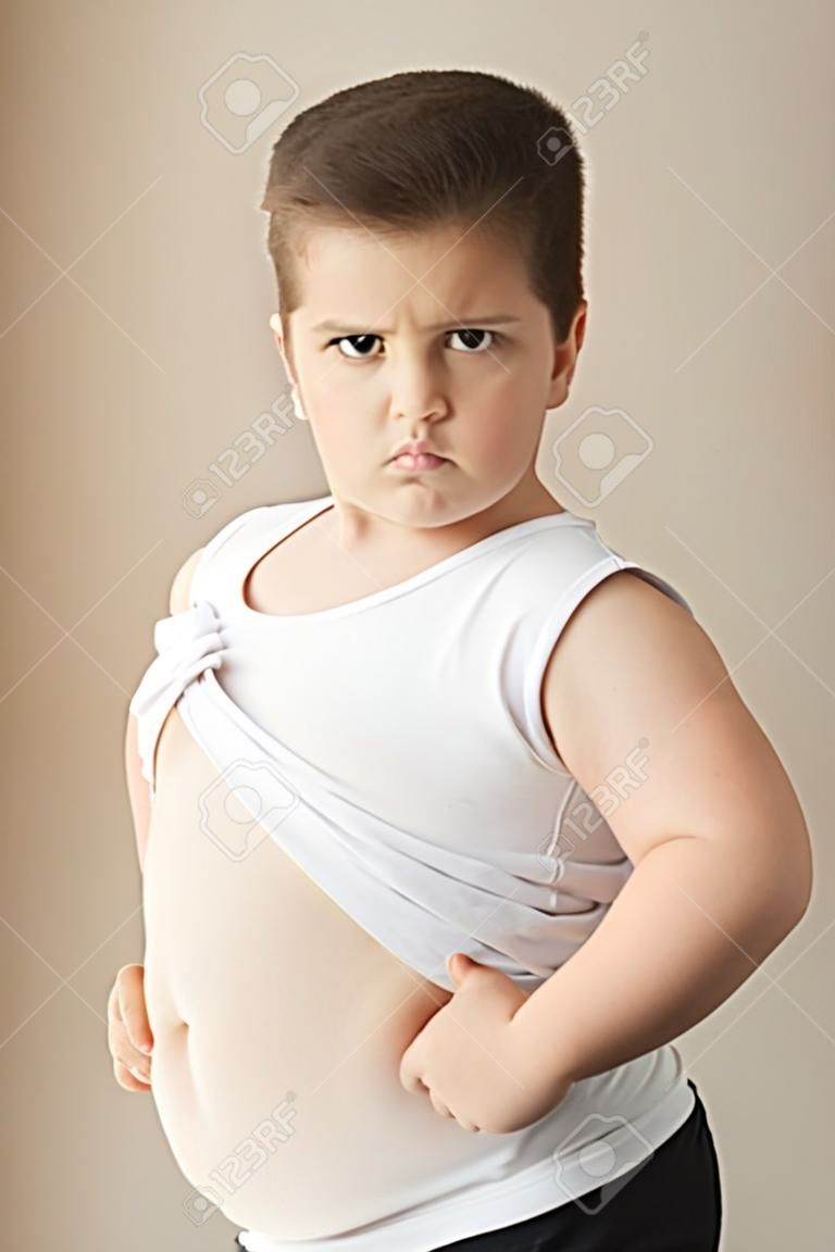 netter fetter Junge in T-Shirt sieht in den Rahmen