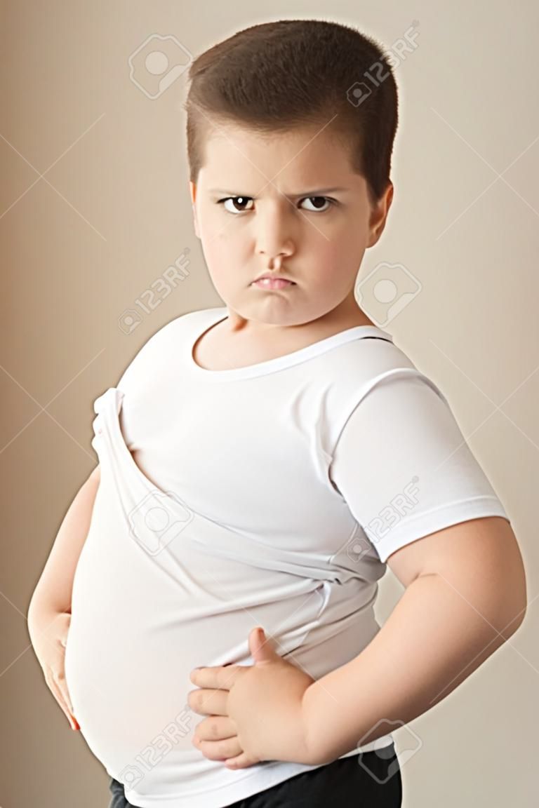 netter fetter Junge in T-Shirt sieht in den Rahmen