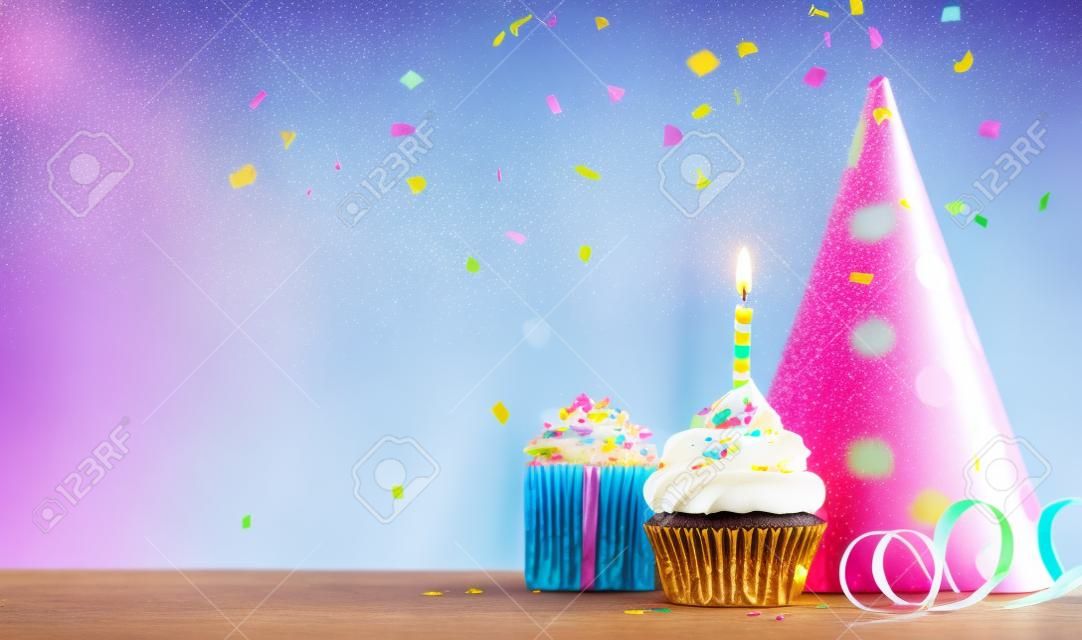 Sfondo di cupcake di compleanno con regalo di compleanno, cappello da festa di compleanno e coriandoli che cadono