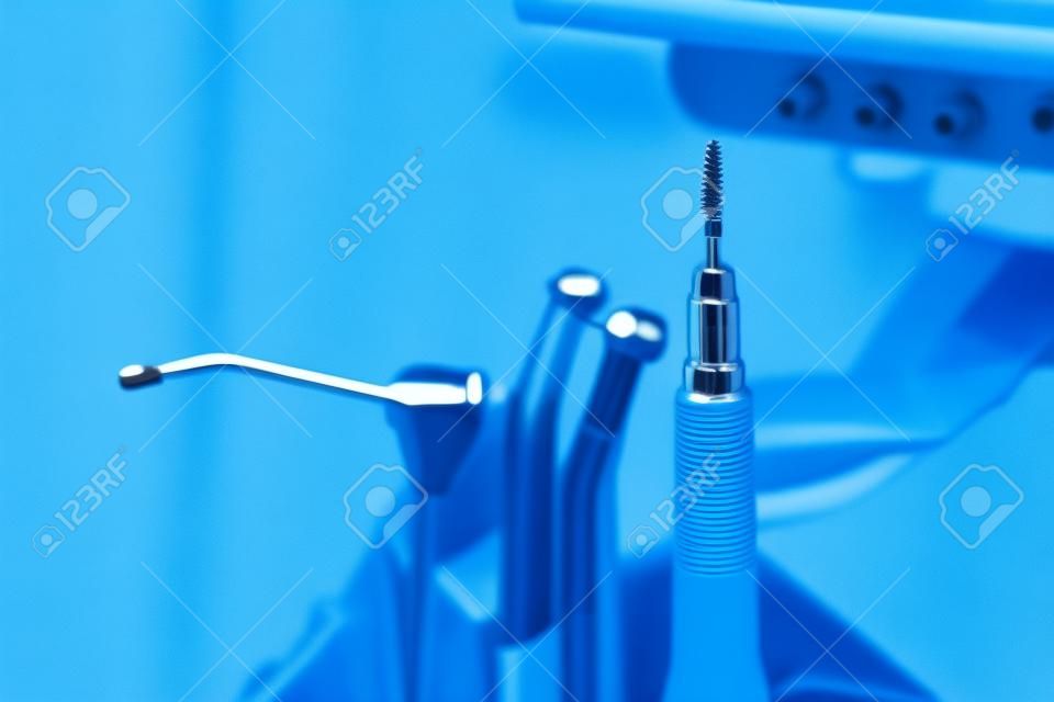 Herramientas metálicas dentista de cerca en una silla de dentista en la Clínica de Odontología (tono azul)