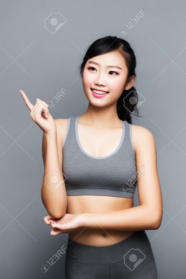 Sport girl look something isolated on grey background. asian beauty