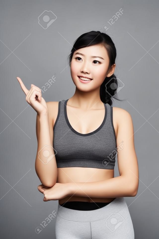 Sport girl look something isolated on grey background. asian beauty