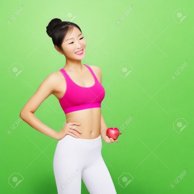 Mujer feliz de la salud en beneficio espectáculo de manzana para la salud con la naturaleza de fondo verde, belleza asiática