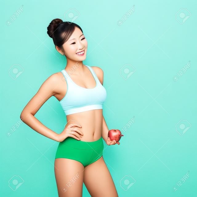Mujer feliz de la salud en beneficio espectáculo de manzana para la salud con la naturaleza de fondo verde, belleza asiática