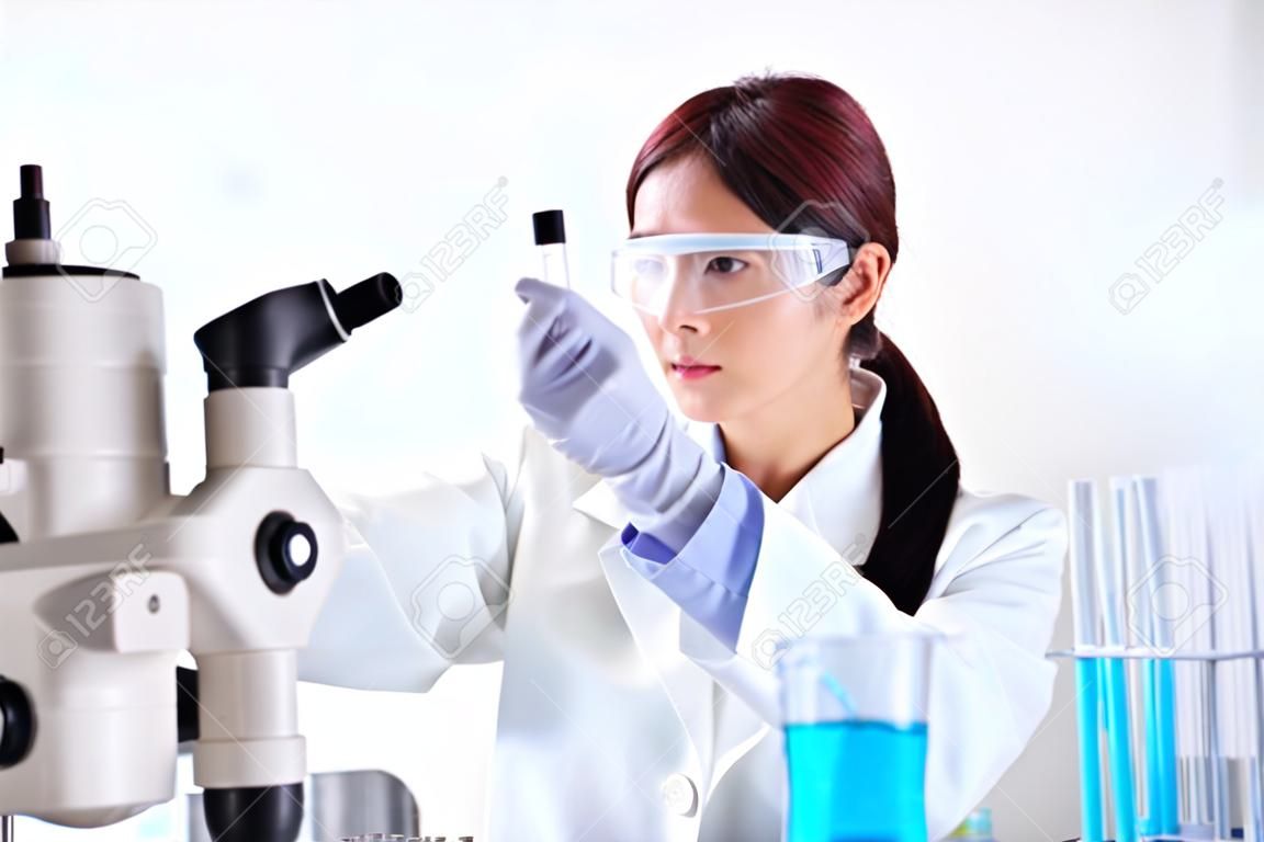 женщина-ученый берет пробирку в лаборатории