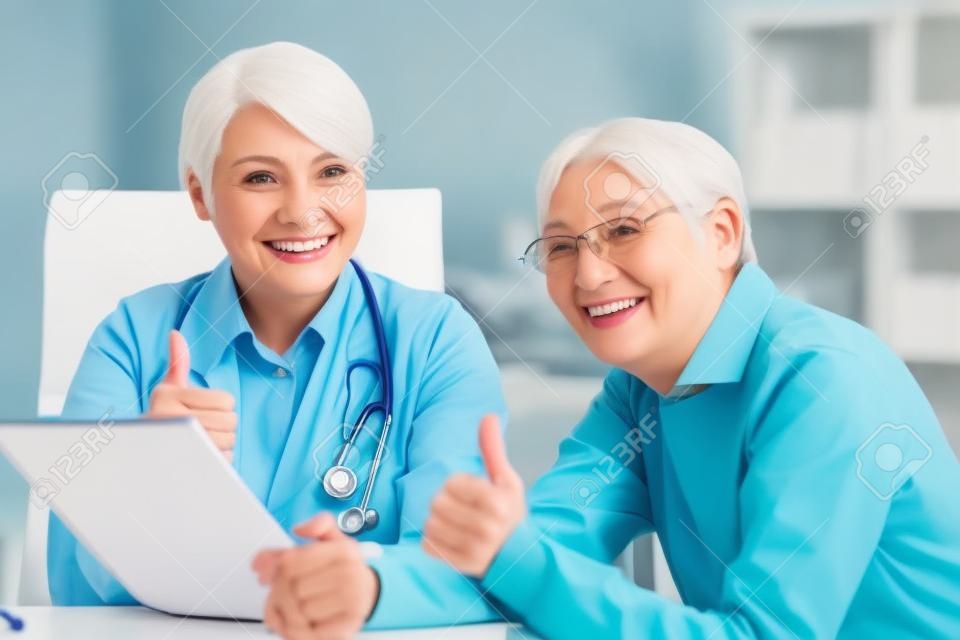 La dottoressa con il paziente anziano mostra i pollici in su