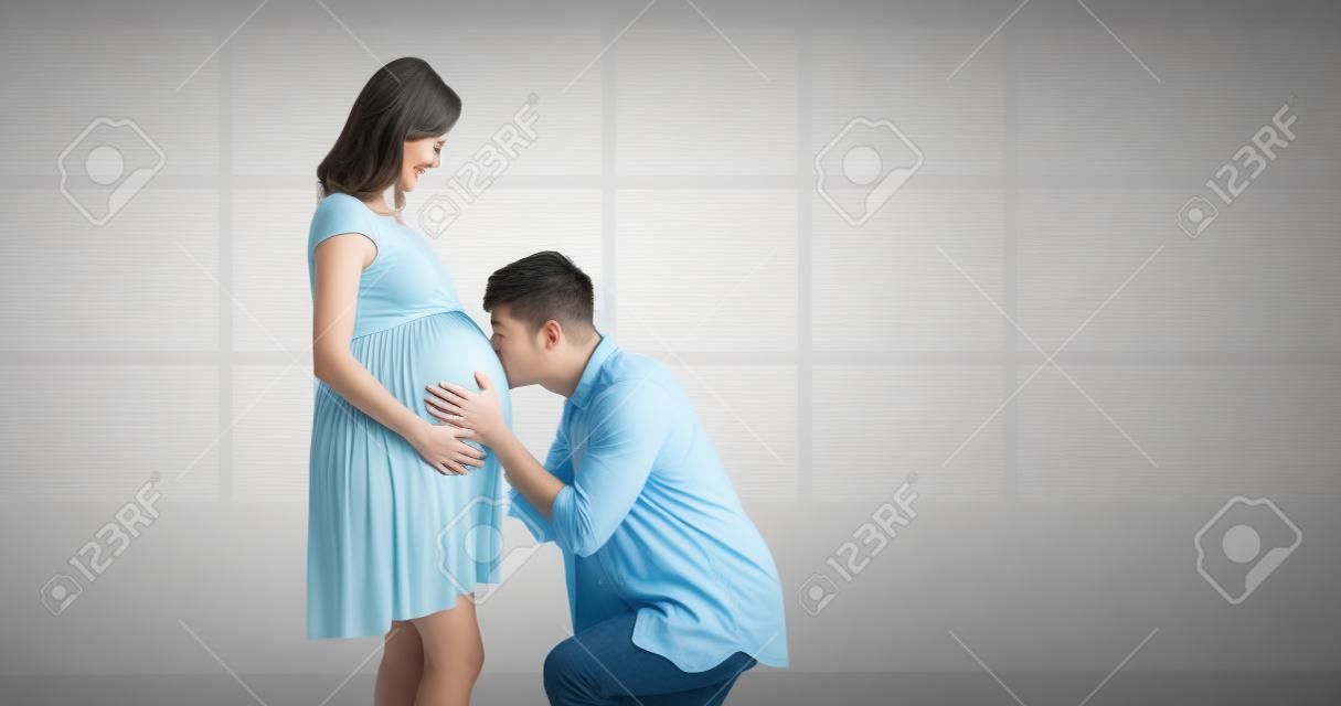 gelukkig zwanger paar verwacht baby en kus de baby door de buik