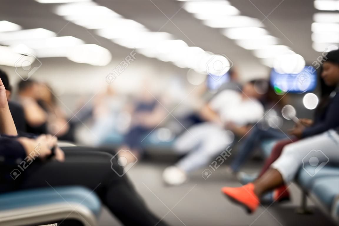 Pessoas embaçadas sentadas esperando no terminal da estação do aeroporto