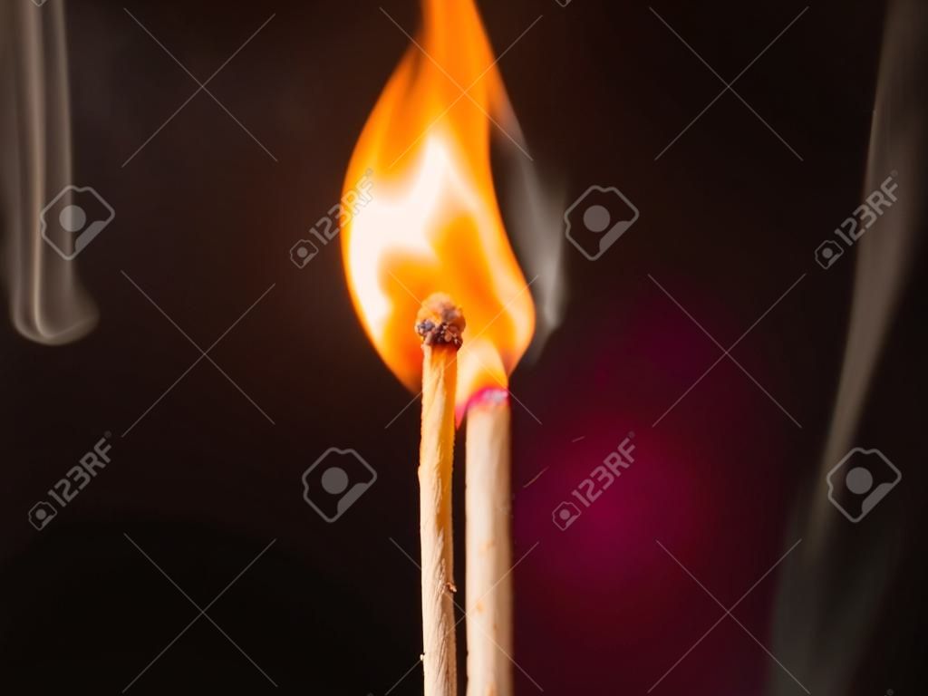 Brennendes Streichholz auf schwarzem Hintergrund. Flamme eines brennenden Streichholzes. Nahaufnahme.