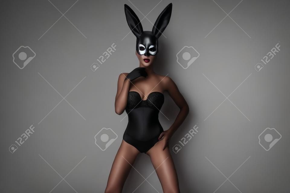 Sexy woman in a black bunny mask isolated on a white background. Female model with mask.