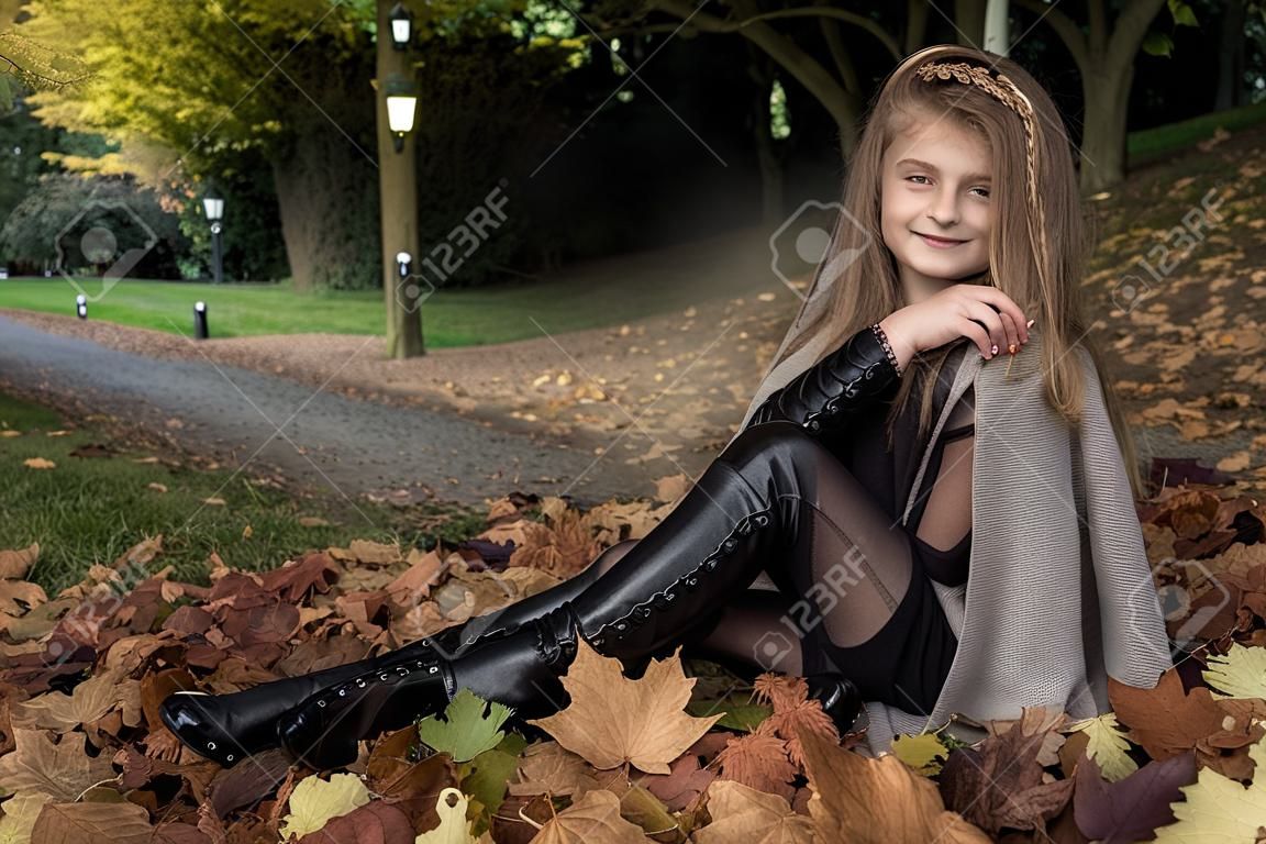 키즈 패션. 가 겨울 옷을 입고 아름 다운 어린 소녀가 공원, 야외에서 배경 나뭇잎. 아동복.