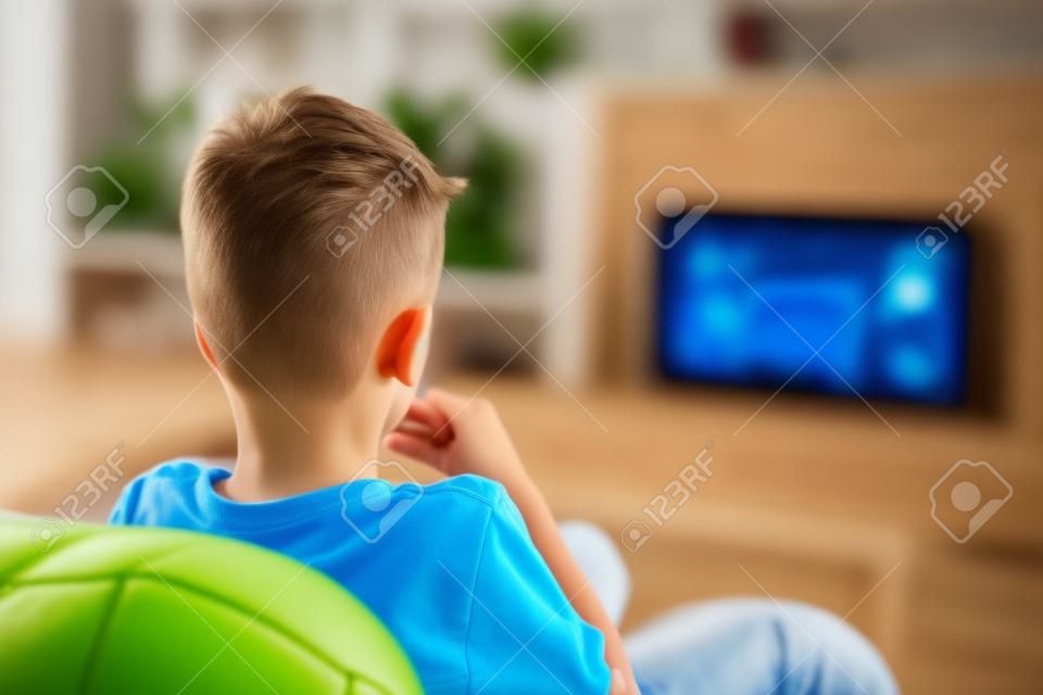 Excited little kid watching soccer match in TV at home