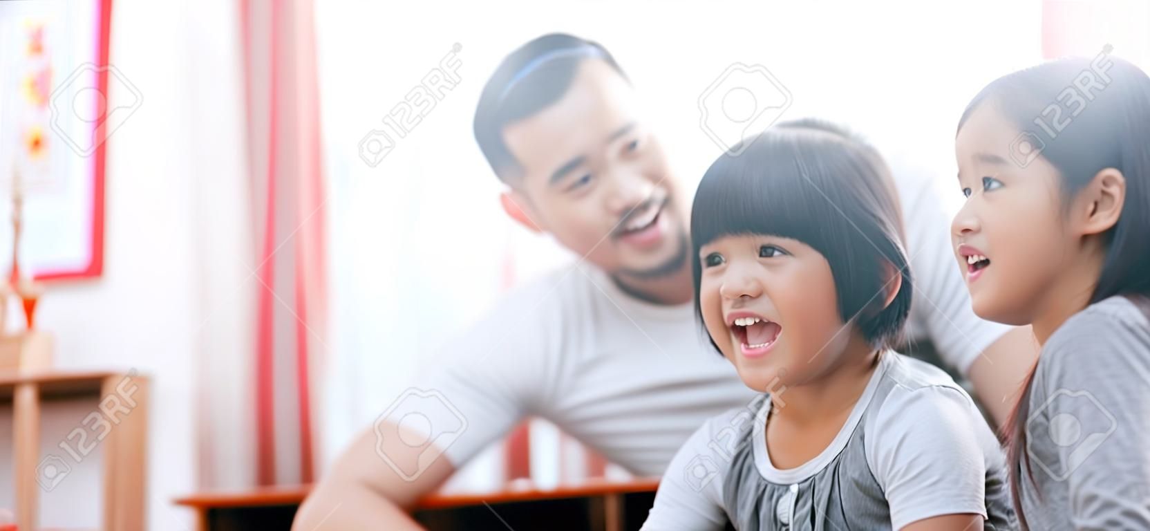 幸せなアジアの家族の肖像画は、リビングルームで一緒に時間を過ごす。家族と家庭の概念