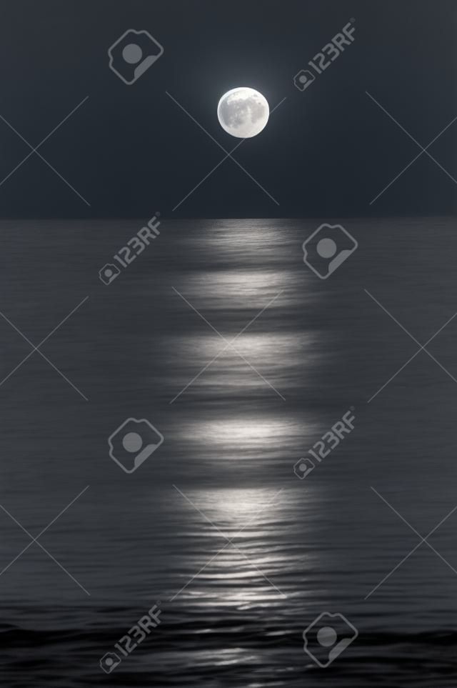 Vollmond-Einstellung am Horizont in den Ozean mit Reflektion scheint durch. Black And White.