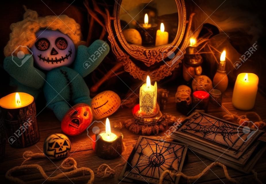 Ritual mágico com boneca de vodu, espelho, velas e cartas de tarô. Conceito de Halloween, místico ou magia de adivinhação com símbolos ocultos e esotéricos. Objetos vintage na mesa de bruxas