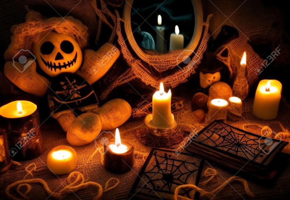 Ritual mágico com boneca de vodu, espelho, velas e cartas de tarô. Conceito de Halloween, místico ou magia de adivinhação com símbolos ocultos e esotéricos. Objetos vintage na mesa de bruxas