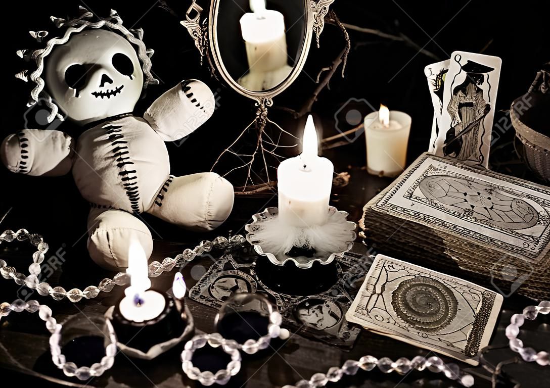 rituale magico con la bambola voodoo, specchio, candele male e tarocchi in stile grunge vintage. Concetto di Halloween, magia mistica o la divinazione con i simboli occulti ed esoterici