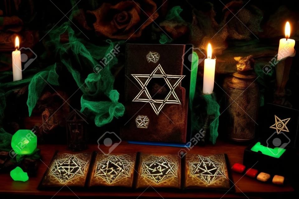 Griezelig heksenboek met pentagram, tarotkaarten, runen, edelsteen, kaars en magische voorwerpen. Esoterische, wicca en occulte achtergrond, waarzeggerij en goddelijke rituelen, mystieke concept