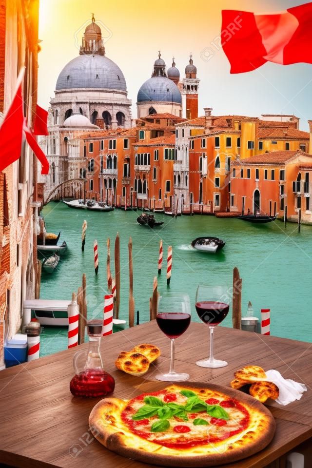 經典的意大利比薩餅和葡萄酒在對威尼斯大運河glases的船隻，意大利