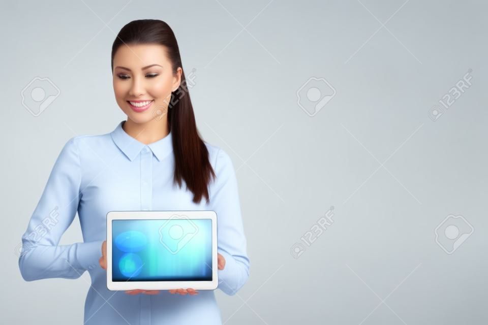 Hermosa mujer de negocios muestra un monitor en blanco en una tableta aislada en blanco