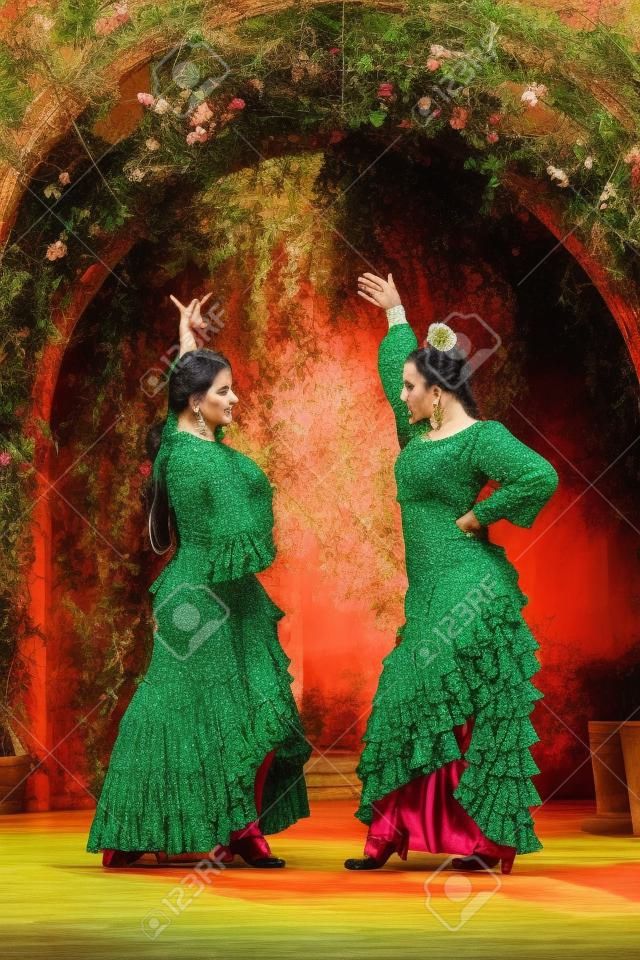 植物のアーチに囲まれて踊るフラメンコ衣装を着た2人の女性の写真素材