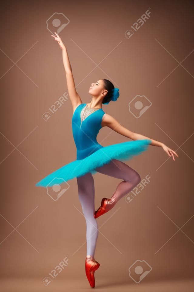 young beautiful dancer posing on a studio background