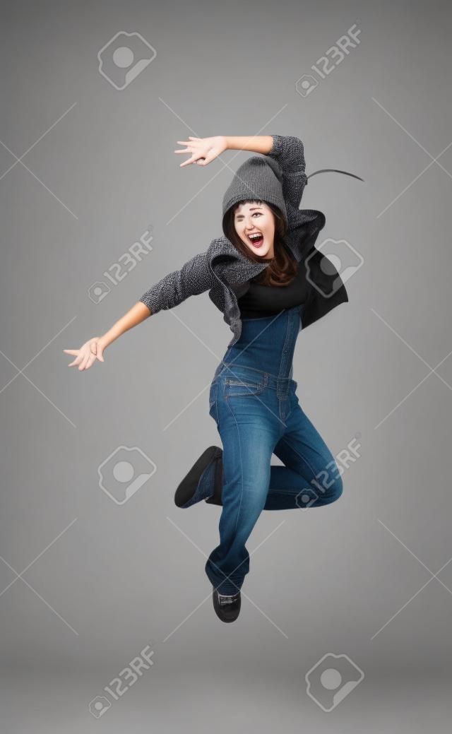 jeune femme sautant sur fond de studio