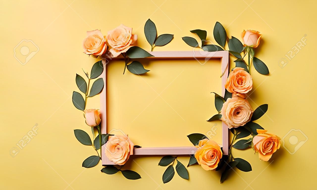 Flowers composition. Frame made of roses on yellow background. Flat lay, top view, copy space. Mock up for product presentation
