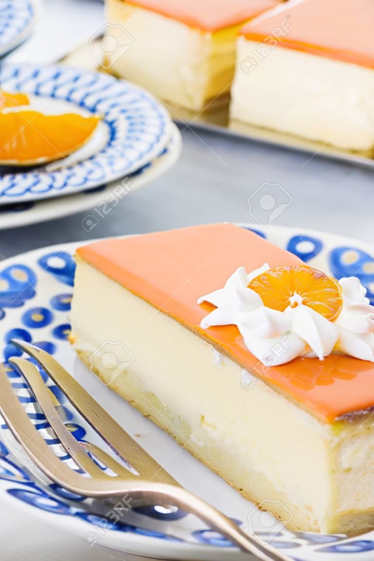 An orange tompouce, traditional Dutch pastry, on a white background. The orange icing on the tompouce is typical for King's Day ('Kongingsdag') on April 27th.