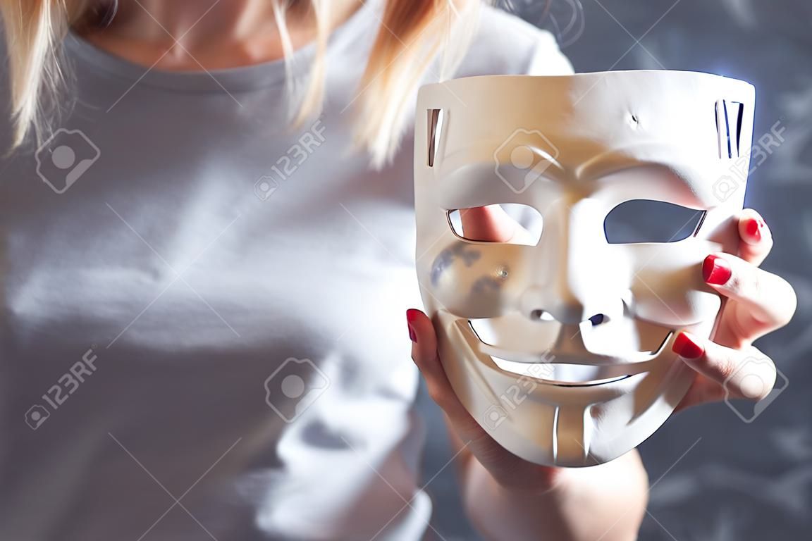 young girl holding anonymous mask