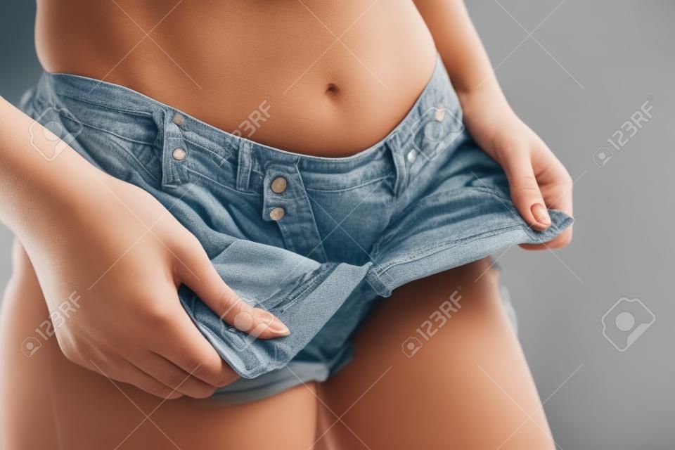 Femme en short enlève son pantalon