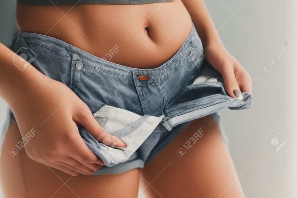 Femme en short enlève son pantalon