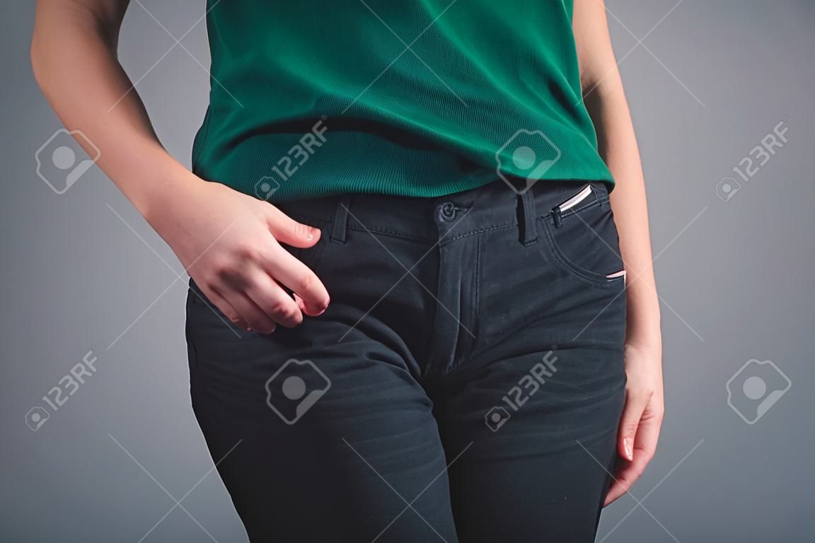 woman put her hands on front pockets on gray background