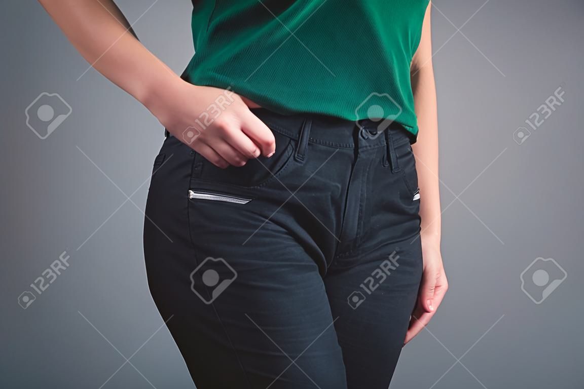 woman put her hands on front pockets on gray background