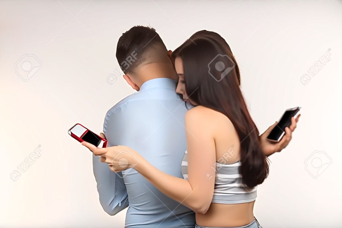 スマートフォン中毒の概念 - 若いカップルが自分の携帯電話で抱きしめて入力する