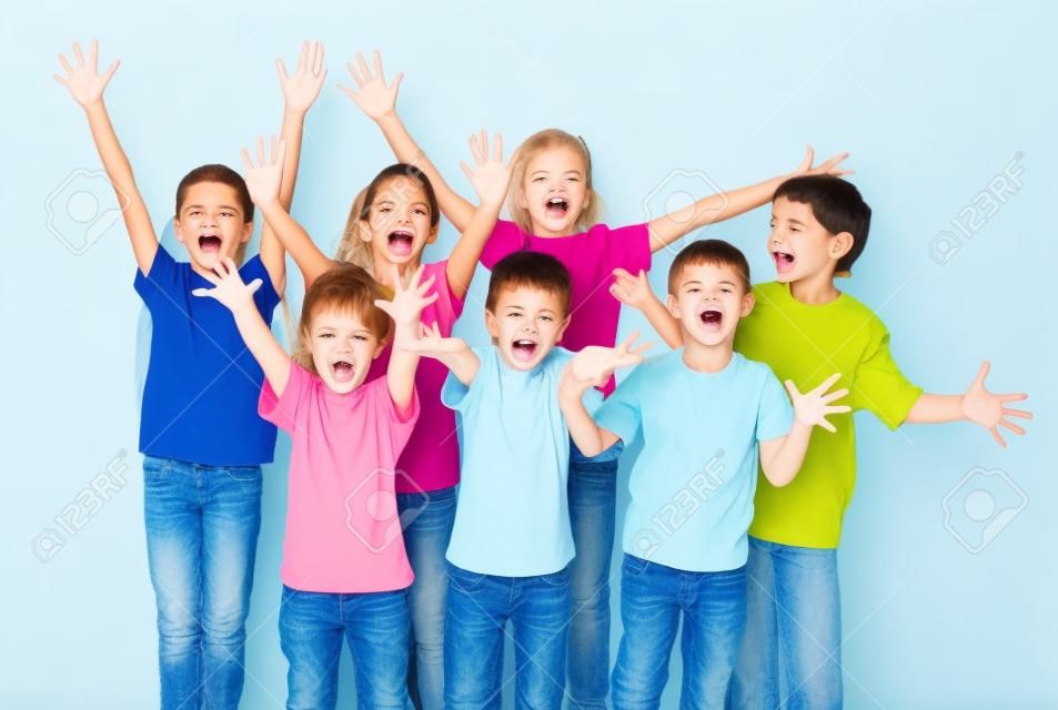 Grupo de niños felices con las manos arriba signo, aislado en blanco