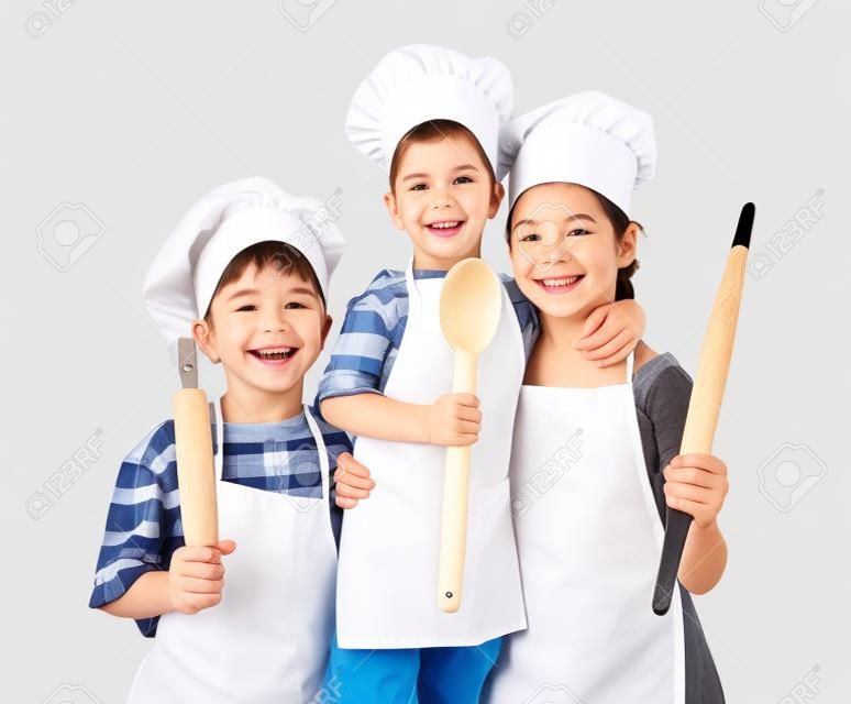Drie kleine glimlachende chefs met lepel en rolspeld, geïsoleerd op wit