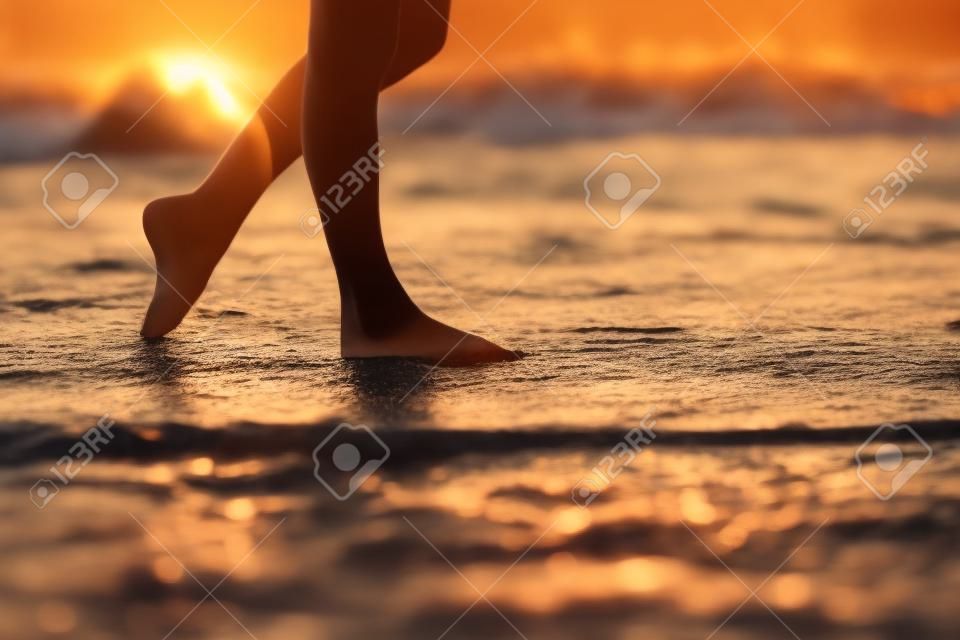 아름다운 젊은 여자 다리 일몰 해변에서